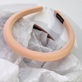 Vue détaillée du serre-tête en satin rose crème montrant l'étiquette en tissu fait main - Orange Clair