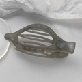 Detalle de una pinza para el cabello gris translúcida con forma de huso y resorte metálico - Gris