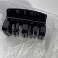 Vista dall'alto di una molletta per capelli nera lucida con design a denti multipli - Nero