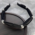 Close-up of pleated black fabric headband with elegant white pearl clusters detail - Black