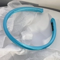 Dettaglio del cerchietto in raso azzurro imbottito con trama di seta ed etichetta - Azzurro