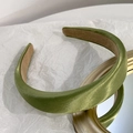 Dettaglio ravvicinato di un cerchietto imbottito verde con finitura satinata e fodera - Verde matcha