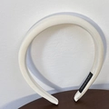 Close-up of cream sponge headband showing fabric texture and handmade label - Milk White