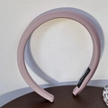 Detail of light purple satin padded headband with handmade label on wooden surface - Pink
