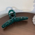 Detail view of large dark green matte hair claw clip on a rustic wooden background - Crossed / Cross Dark Green