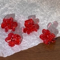 Detail view of mini red floral hair claws made of resin with sturdy metal springs - Orange Red