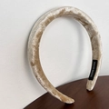 Detail of a handmade champagne velvet padded headband with soft texture on a wooden table - Khaki