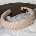 Gros plan sur le bandeau en tricot beige avec étiquette faite main et texture en spirale - Khaki Clair