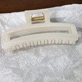 Vue détaillée de la pince à cheveux rectangulaire en résine crème avec ressort doré - Beige