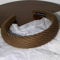 Détail du bandeau en tricot marron foncé avec étiquette fait main sur papier blanc - Marron