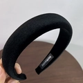 Primer plano de la diadema de terciopelo negro con detalle de etiqueta artesanal - Negro