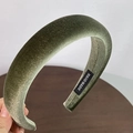 Detalle de diadema de terciopelo verde oscuro con acolchado grueso y etiqueta tejida a mano - Verde