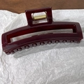 Détail d'une grande pince à cheveux rectangulaire bordeaux avec ressort doré - Café