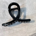 Dettaglio di un fermaglio per capelli nero lucido con design incrociato su sfondo bianco - Nero Croce