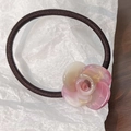 Detailed macro view of a pink resin rose flower on a high-elastic brown hair tie - Pink and White Pattern