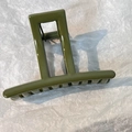 Detail view of olive green hair claw clip showing a metal spring and glossy finish - Green Rectangle