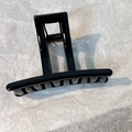 Detail view of large black square hair claw clip with glossy resin finish and metal spring - Black Rectangle