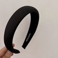 Detalle de diadema acolchada negra que muestra tela mate y etiqueta de hecho a mano - Negro