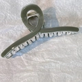 Dettaglio di un fermaglio per capelli verde oliva da 13cm con molla in metallo e finitura lucida - Grigio