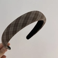 Detailed macro view of the brown plaid fabric texture and thick padded headband design - Plaid