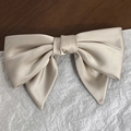 Close-up of elegant champagne satin bow hair clip with smooth texture and vintage French style - Khaki