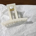Close-up of a cream jelly rectangle hair claw clip with a strong gold metal spring - Beige