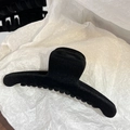 Gros plan détaillé d'une grande pince à cheveux floquée noire sur fond de papier texturé - Modèle Large Incurvé / 11cm / Noir