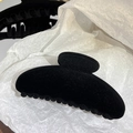 Gros plan sur une grande pince à cheveux noire mate flocage sur fond texturé - Modèle Demi-Lune Arrondi / Noir