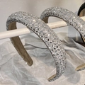 Close-up of sparkling full rhinestone padded headband with premium silver crystal detailing - White