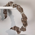 Close-up detail of a brown pleated fabric headband with elegant white pearls for hair styling - Light Coffee