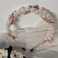 Dettaglio del cerchietto con perle, fiocco rosa e coperture protettive antiscivolo nere - Rosa