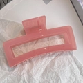 Macro detail of large translucent pink rectangular claw clip with metal spring - Grapefruit Red