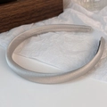 Primer plano de la diadema acolchada de satén champán con textura brillante y diseño elegante - Gris Plata