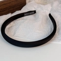 Detalle de la textura de satén negro y la etiqueta hecha a mano en la diadema elegante - Negro