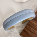 Détail d'un serre-tête en similicuir bleu clair avec rembourrage épais et doublure jaune - Bleu