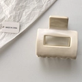 Nahaufnahme einer cremefarbenen matten Haarklammer mit hohlem rechteckigem Design - Beige