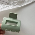 Detailed close-up of a mint green square hollow hair claw clip held by hand - Mint Green
