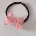Detail of pink resin bow hair tie with France Handmade engraved text on brown elastic - Pink