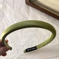 Dettaglio del cerchietto in seta verde oliva con etichetta fatta a mano e raso pregiato - Stile Stretto Verde