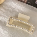 Détail d'une pince à cheveux en résine beige avec perles et strass micro-incrustés - Rectangulaire