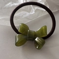 Detail of olive green acrylic bow hair tie with France Handmade gold lettering - Green