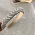 Dettaglio di un cerchietto bombato con perle bianche e strass scintillanti - Perla bianca con strass