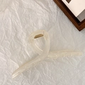 Primer plano de una pinza para el pelo crema de 13 cm con resorte dorado sobre papel blanco - Cruzado / Grande / Beige