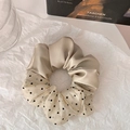 Détail d'un chouchou à pois champagne et beige en tissus élégants de satin et de mousseline - Abricot