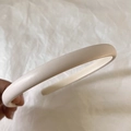 Close-up of minimalist cream leather headband with fine texture on a white background - Milky White