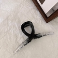 Dettaglio di un grande fermaglio per capelli in resina con sfumatura nero-trasparente - Nero