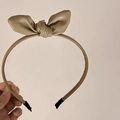 Macro detail of khaki leather headband featuring a vintage-style 3D bow and textured finish - Khaki