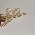 Detalle de una pinza para el cabello con lazo de aleación dorada y perlas blancas incrustadas - Estilo Perla Artificial