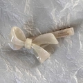 Détail d'une barrette noeud en acétate crème avec éclat nacré et pince métallique dorée - Blanc Perle