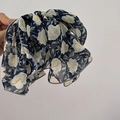 Detail einer blauen floralen Chiffon-Haarspange mit Stoffstruktur und großer Schleife - Marineblau